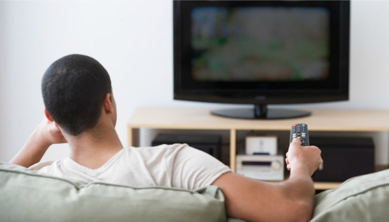 Muz který sleduje na guači televizi